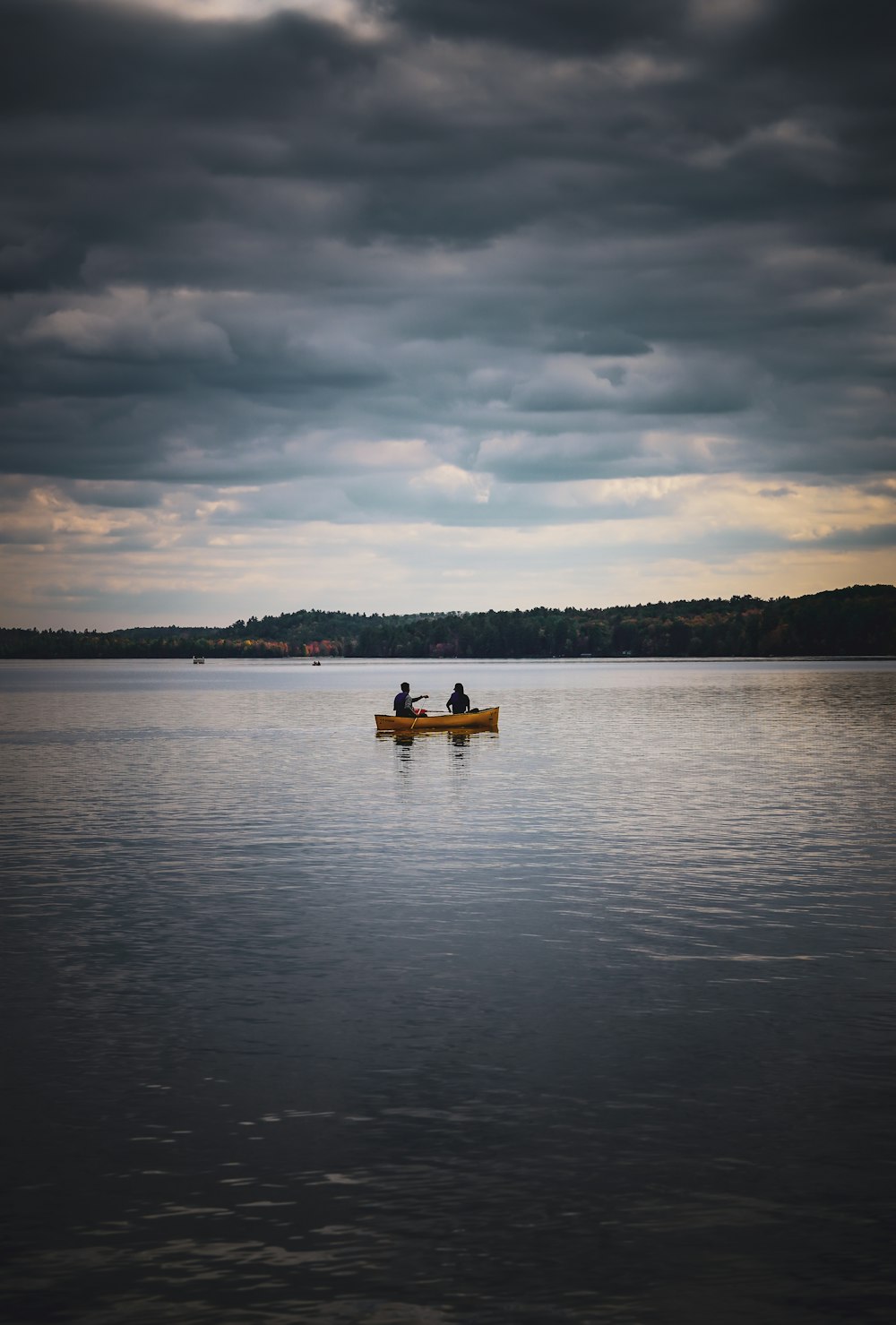 two people in a boat on a large body of water