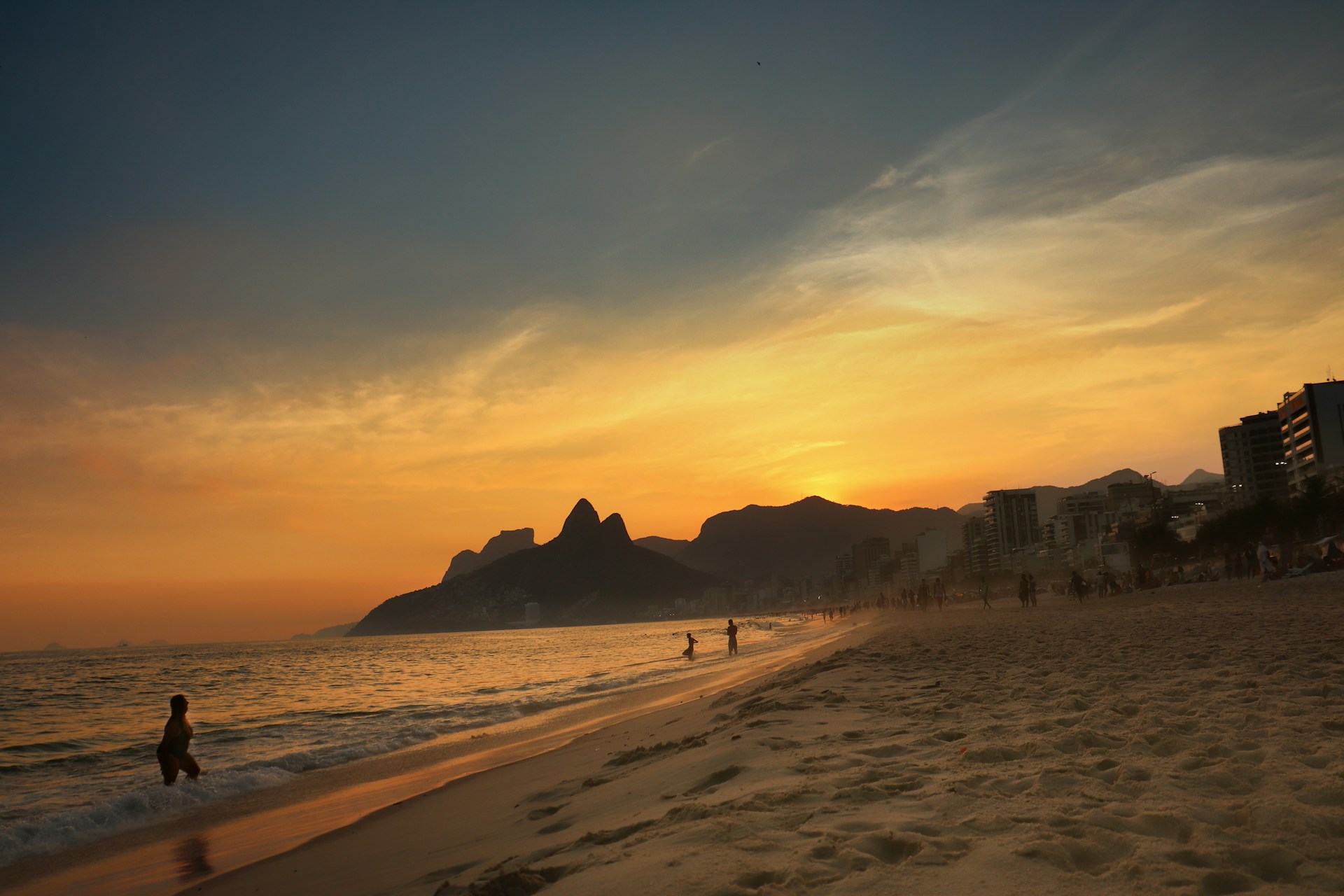 a person walking on a beach at sunset