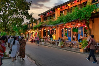 A vibrant street scene at golden hour with people and colorful buildings.