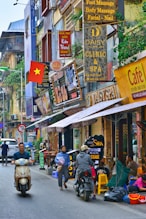 a city street full of shops in Hanoï