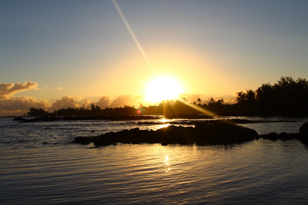 the sun is setting over a body of water