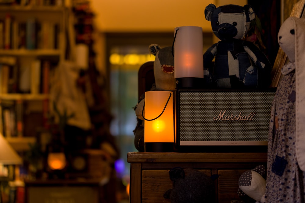 a teddy bear sitting on top of a table next to a lamp