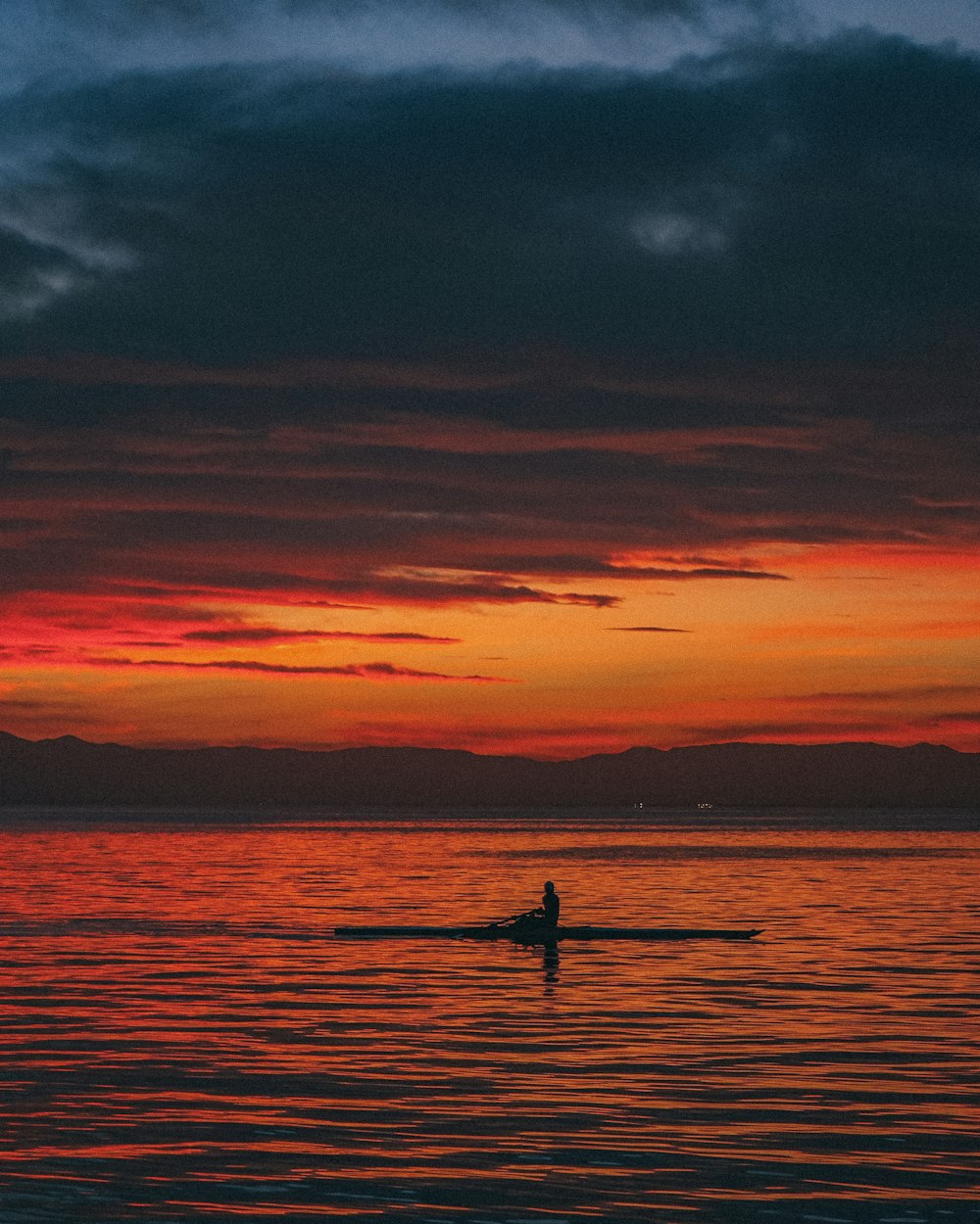 a person on a surfboard in the water at sunset