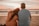 a man and woman sitting on the beach watching the sunset
