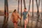Couple laughing naturally while walking hand in hand on a quiet beach at sunset