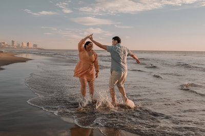 a man and a woman standing in the water at the beach