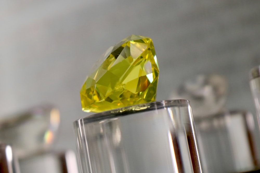 a yellow diamond sitting on top of a glass block