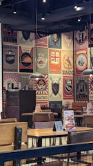 A colorful, modern dining area with hot pink and bright yellow accents and happy customers enjoying tacos.