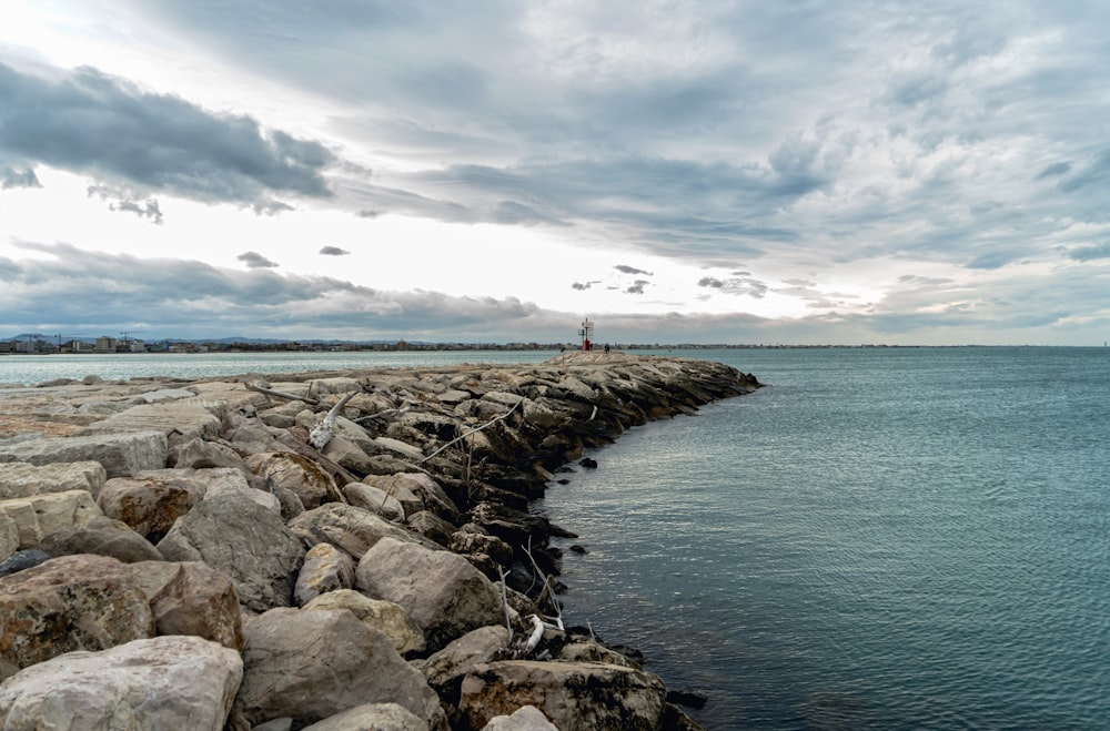 a large body of water sitting next to a rocky shore