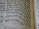 A close-up view of a page from an open book with text written in English. The text is in two columns and appears to be from a religious or historical book, mentioning names and events.