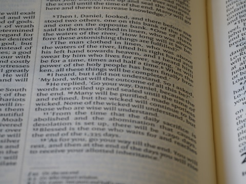 A close-up view of a page from an open book with text written in English. The text is in two columns and appears to be from a religious or historical book, mentioning names and events.