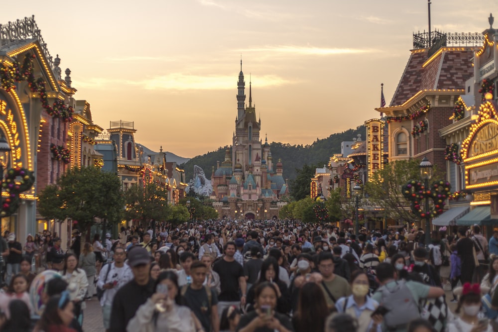 a crowd of people walking down a street next to tall buildings