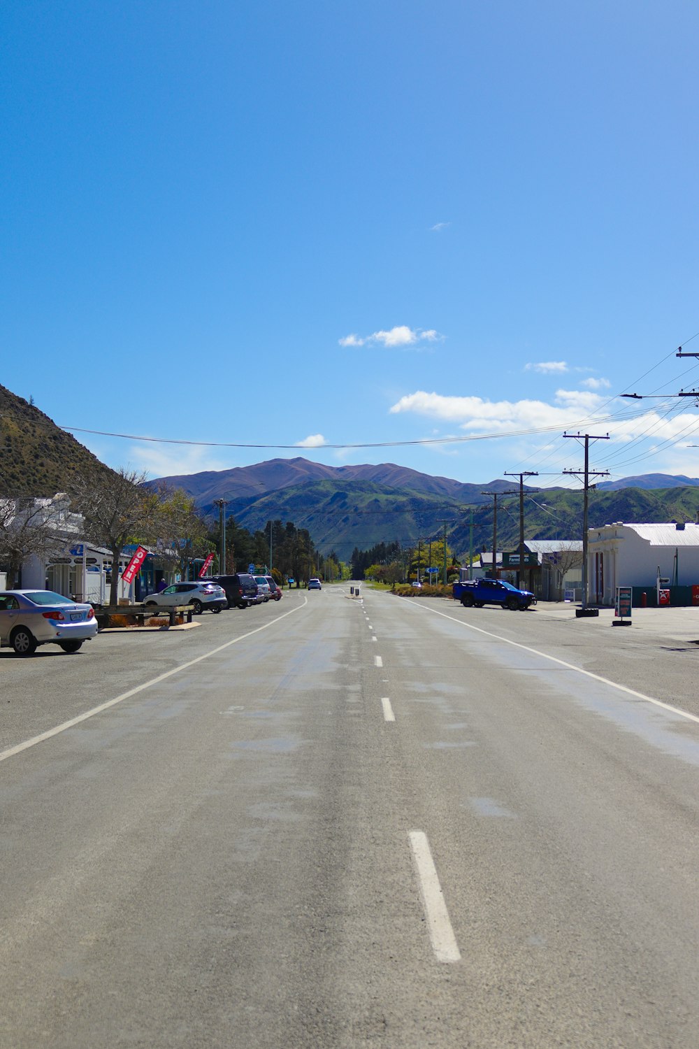 a long empty street with mountains in the background