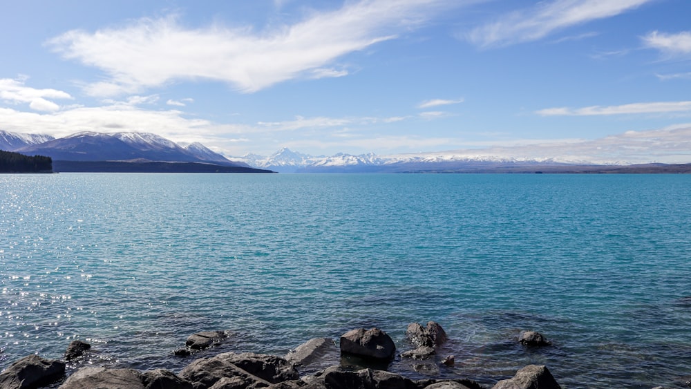 a large body of water with mountains in the background