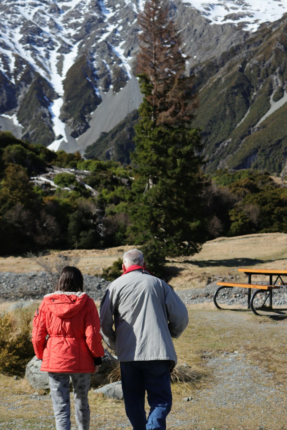 a man and a woman walking towards a picnic table