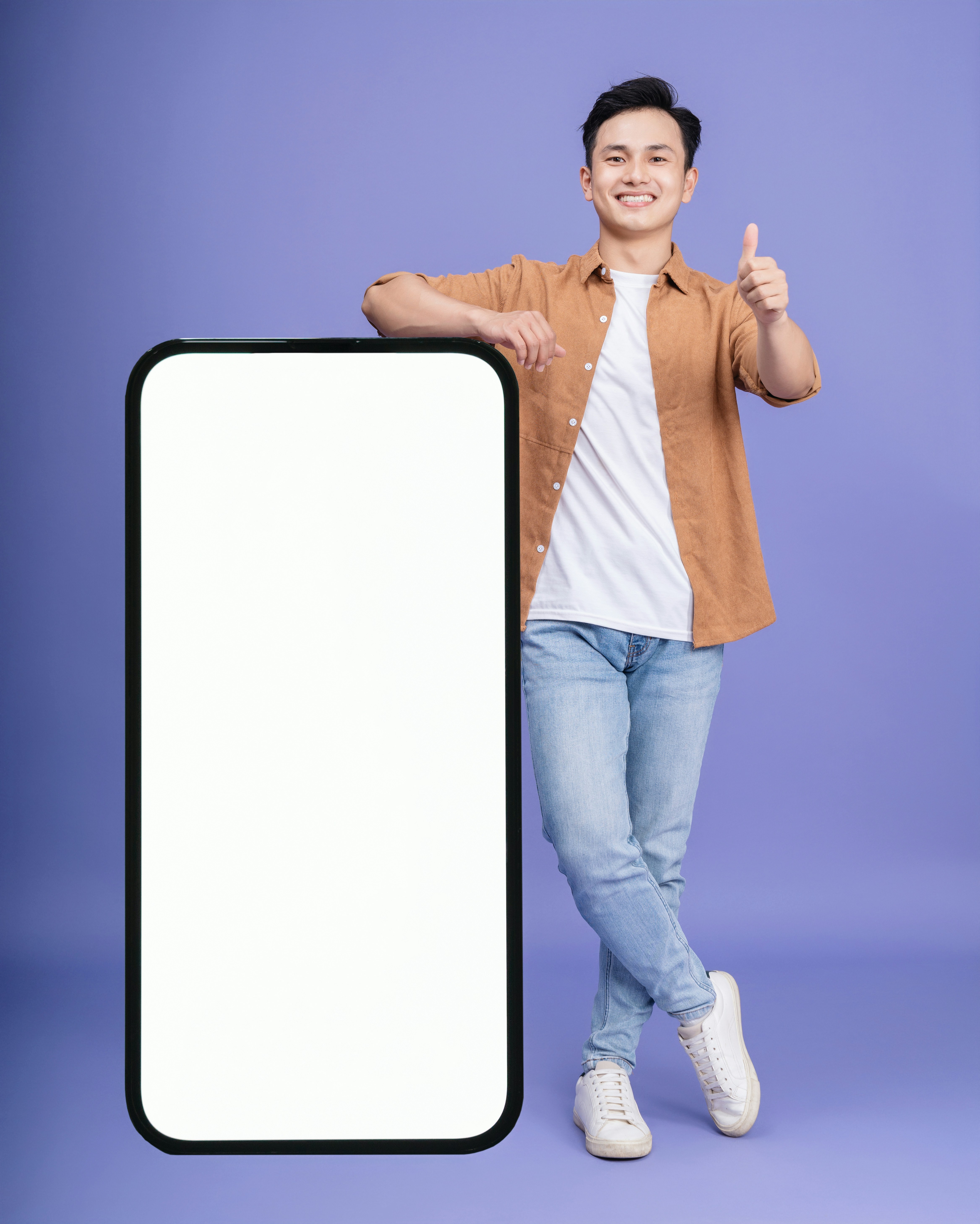 Happy young man holding a phone showing the yallayalla app with delivery in progress.