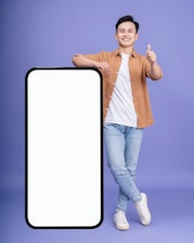 A cheerful young job seeker holding a phone showing a confirmation of a successful online job application.