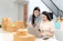 A smiling professional woman working alongside a friendly AI assistant on a laptop.