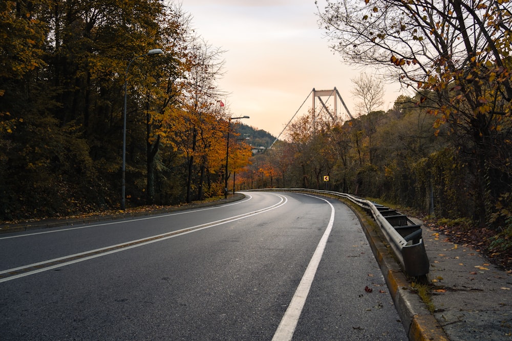 an empty road with a bridge in the background