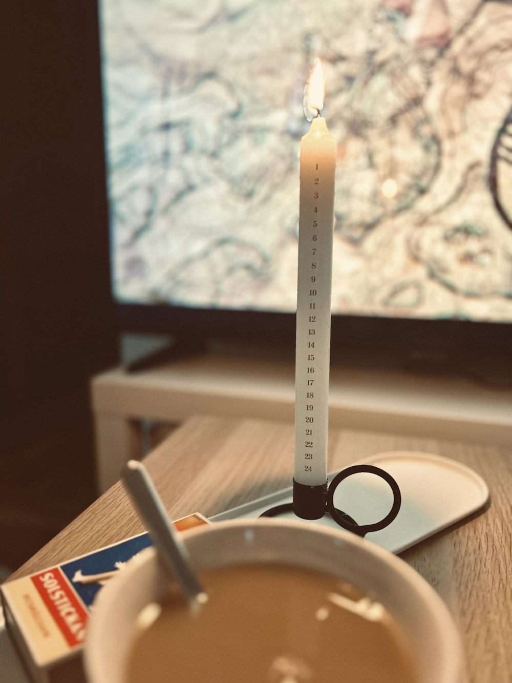 a cup of coffee and a candle on a table