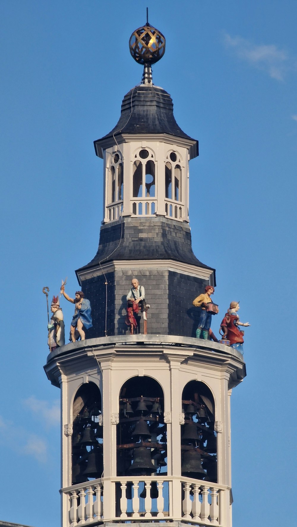 a clock tower with statues on top of it