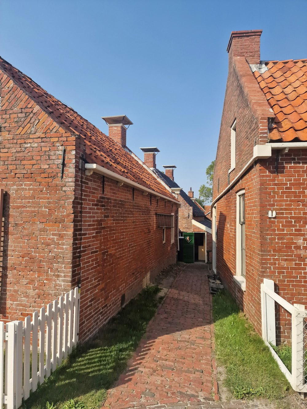 a brick building with a white picket fence