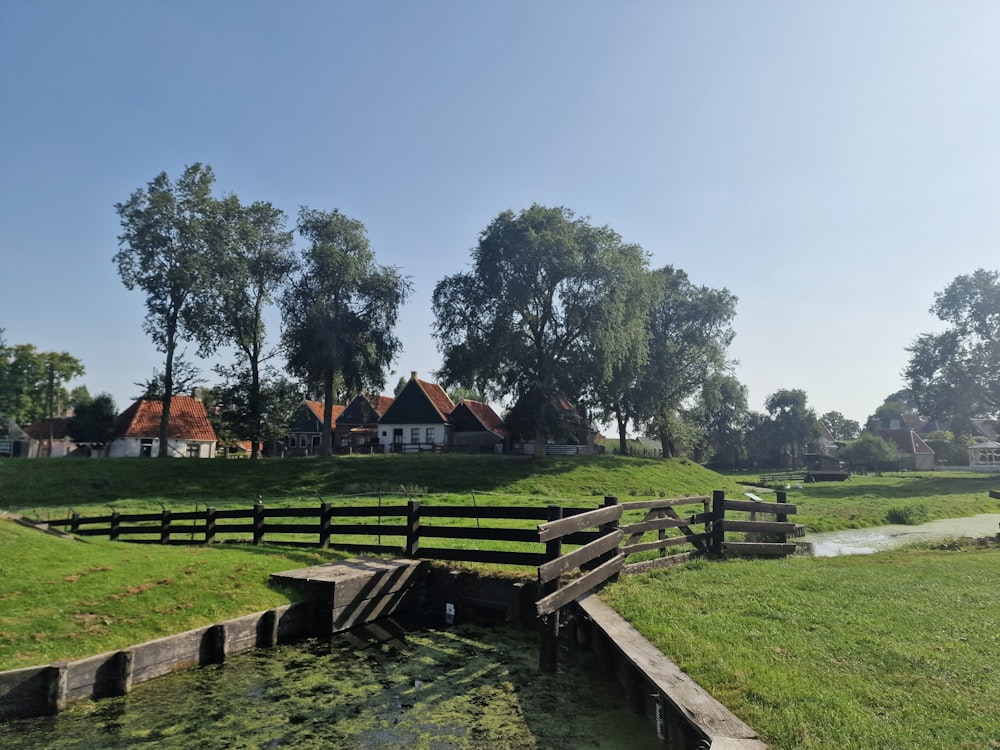 a wooden fence in the middle of a grassy field