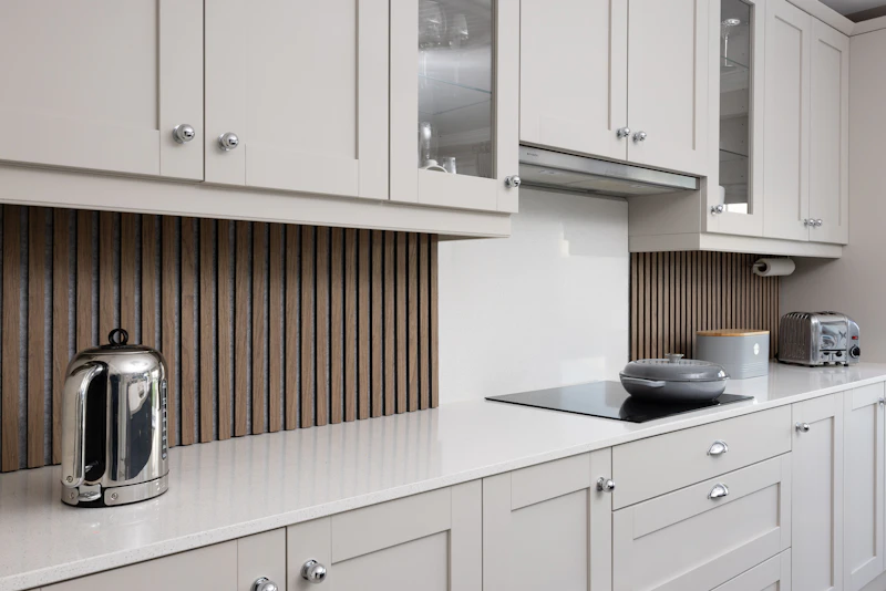 Fitted shaker-style kitchen with slatted wood splashback and quartz worktops