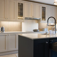 a kitchen with white cabinets and a black island