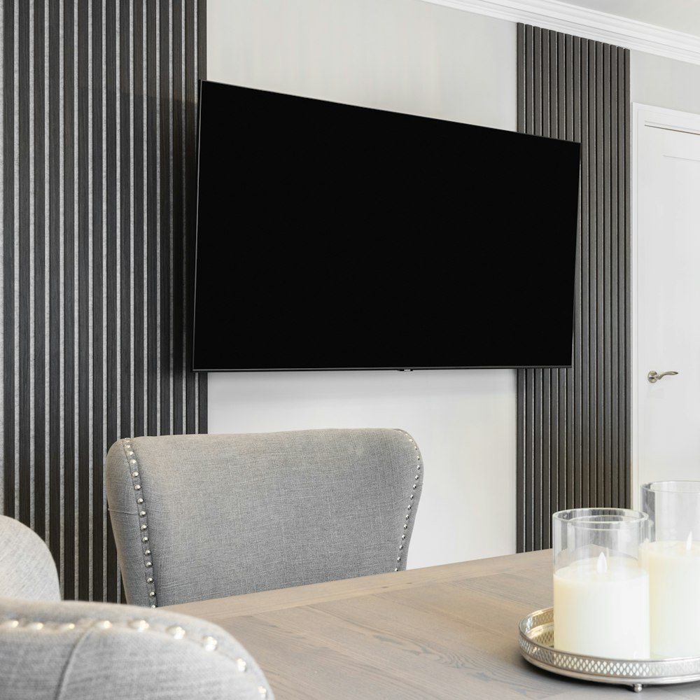 a flat screen tv mounted to a wall above a wooden table