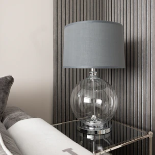 Close-up of a modern lamp casting a warm glow on a stylish side table.