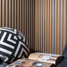 a black and white pillow sitting on top of a wooden table