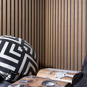 a black and white pillow sitting on top of a wooden table