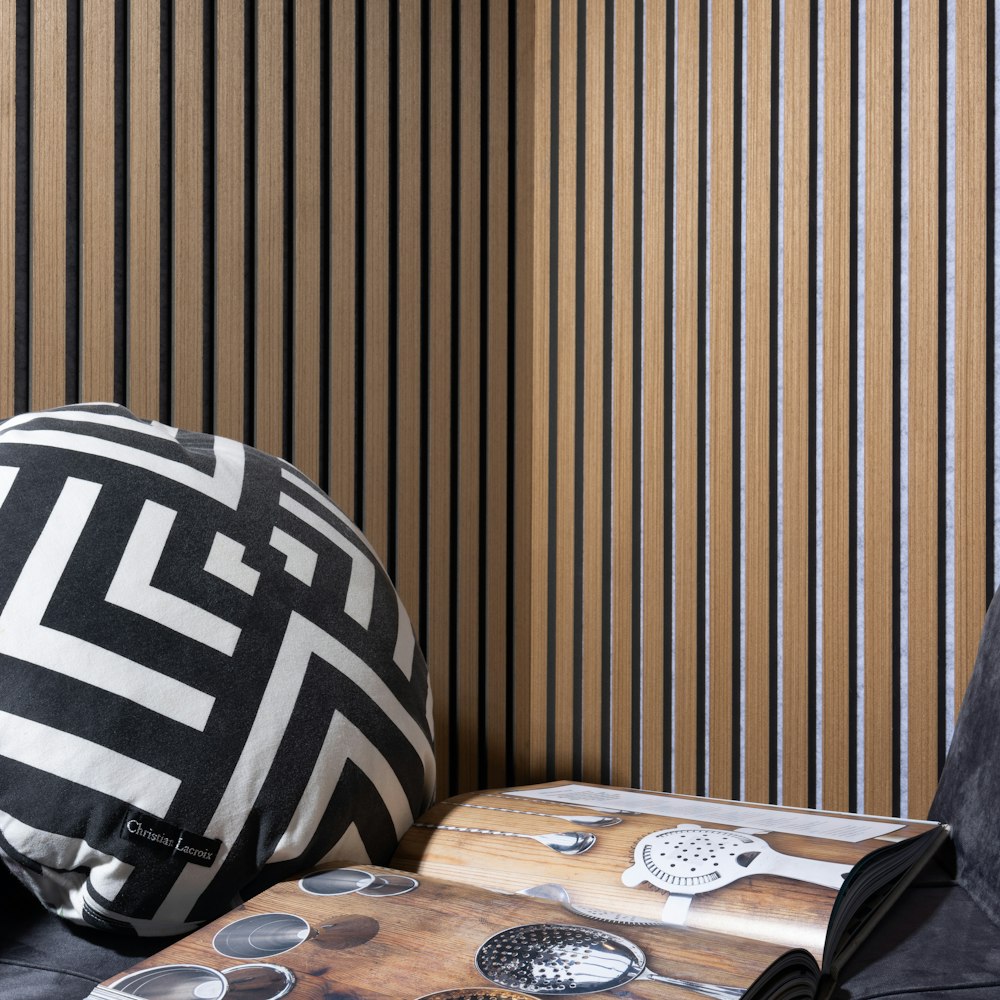 a black and white pillow sitting on top of a wooden table