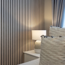 a white bed sitting next to a window covered in curtains