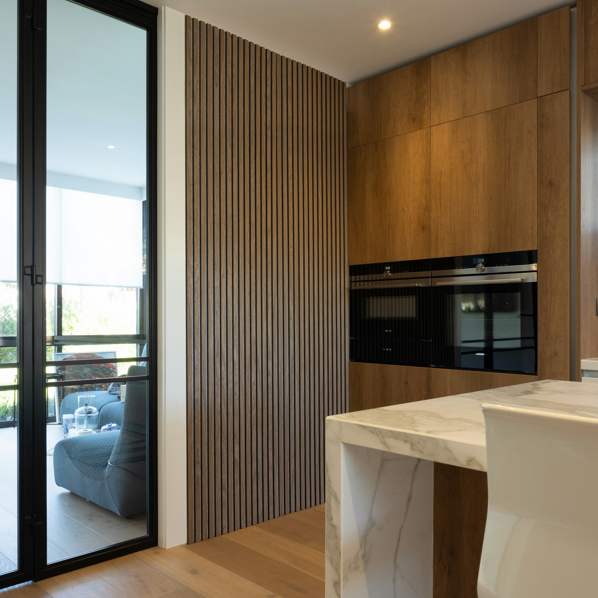 a kitchen with a sink, oven, and sliding glass doors