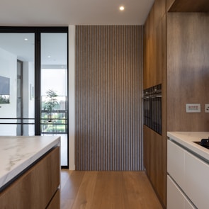 a kitchen with wooden cabinets and white counter tops