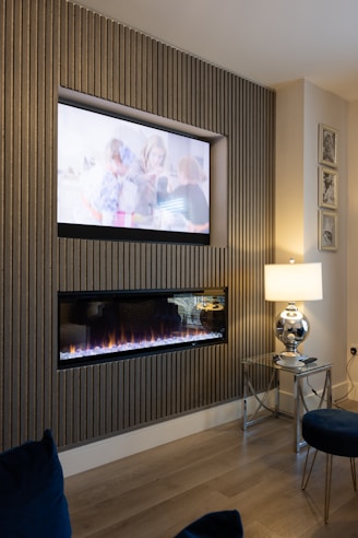 A modern living room featuring decorative wall panels with warm lighting and cozy furniture.