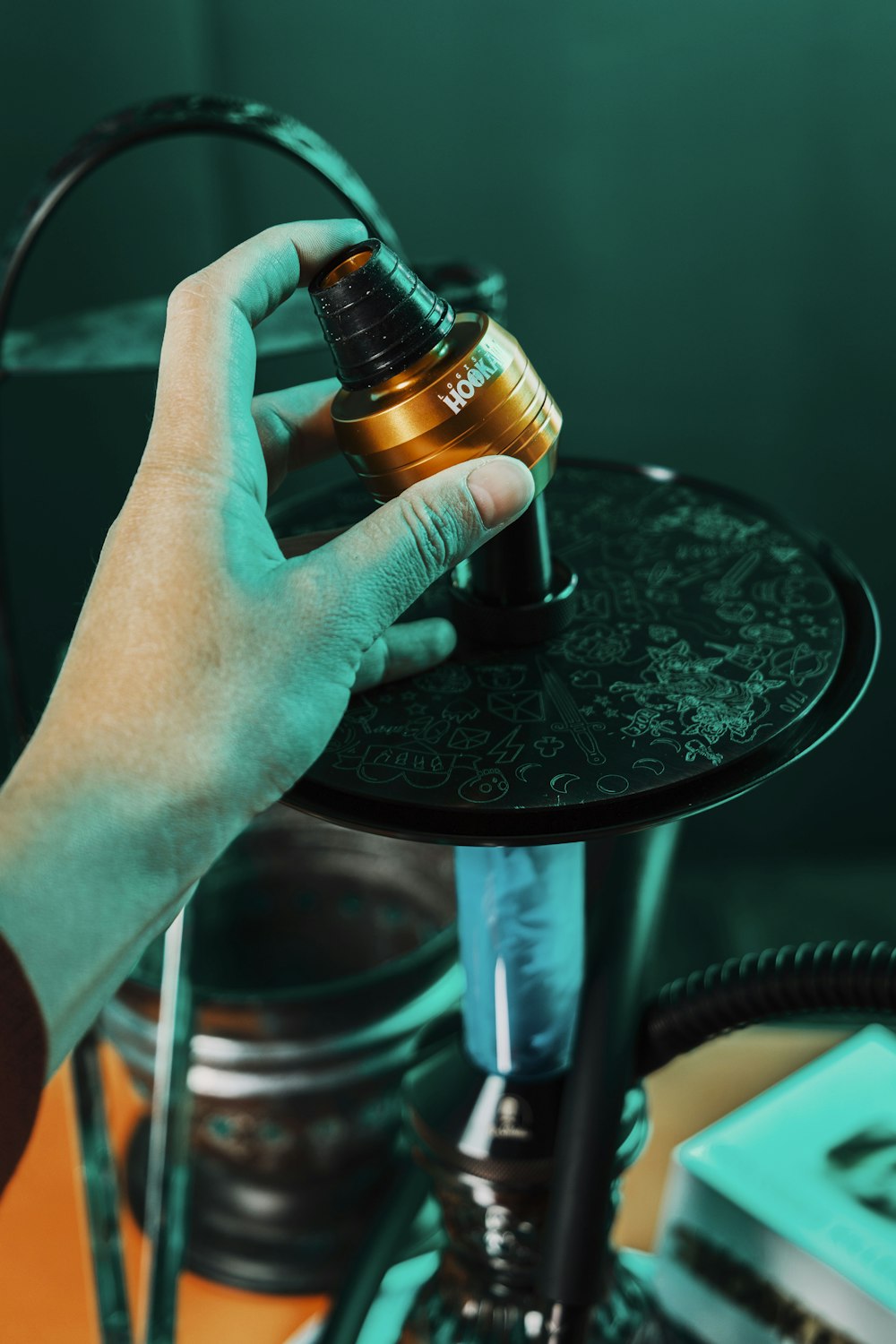 a person is holding a metal object on a table