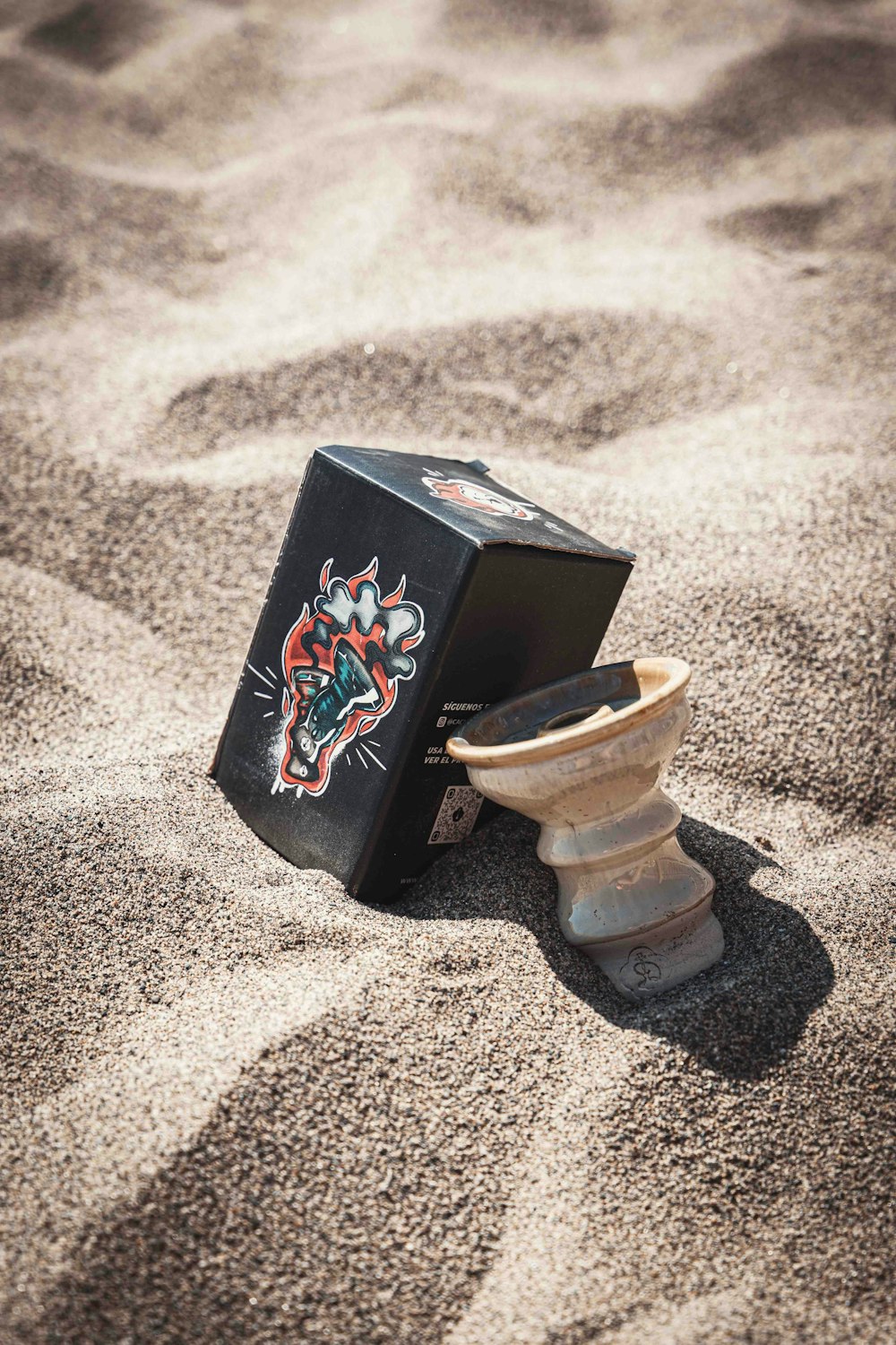 une boîte noire posée sur une plage de sable