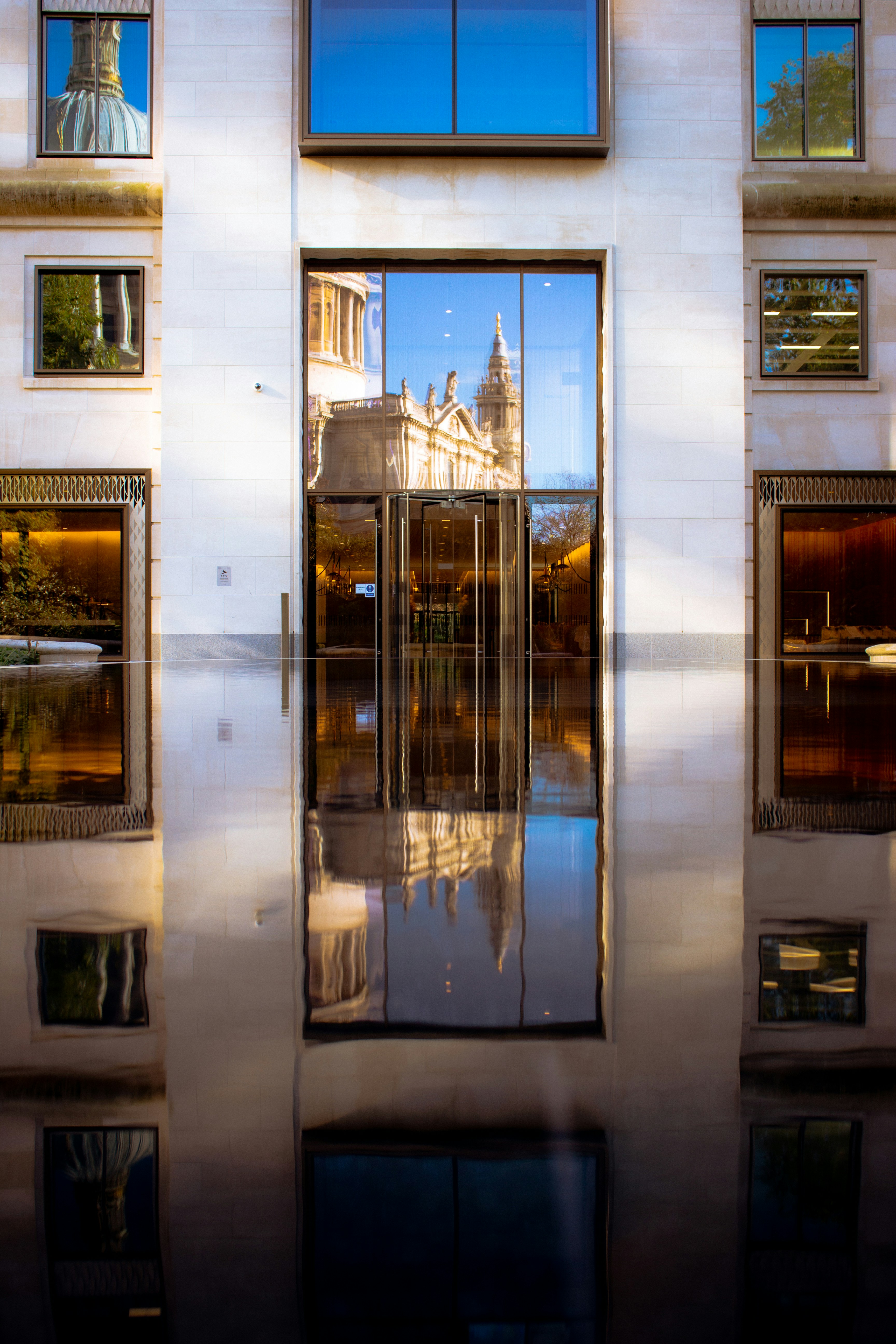 A reflection of a building in the windows of another building photo ...