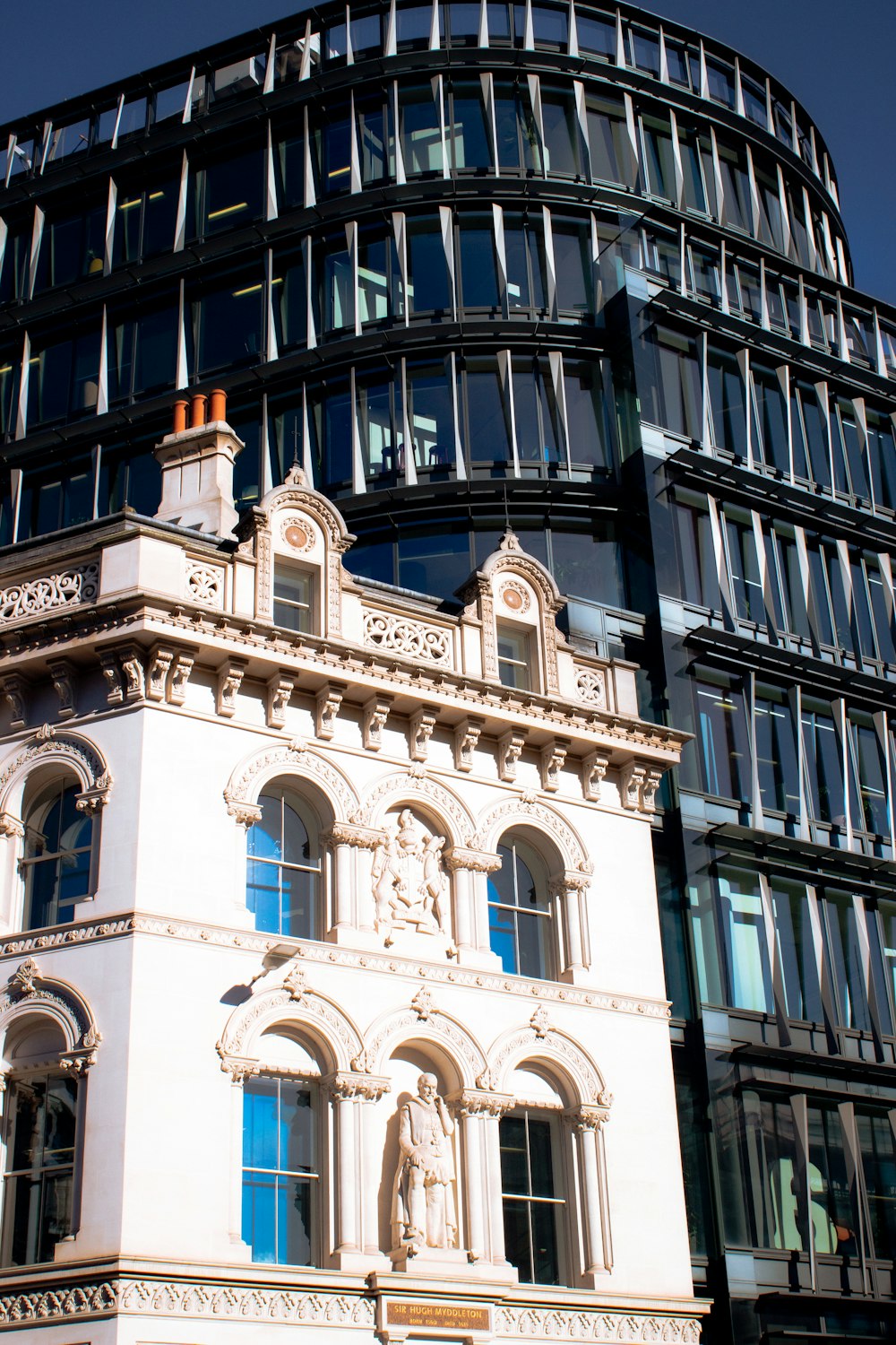 a tall building with many windows next to a tall building