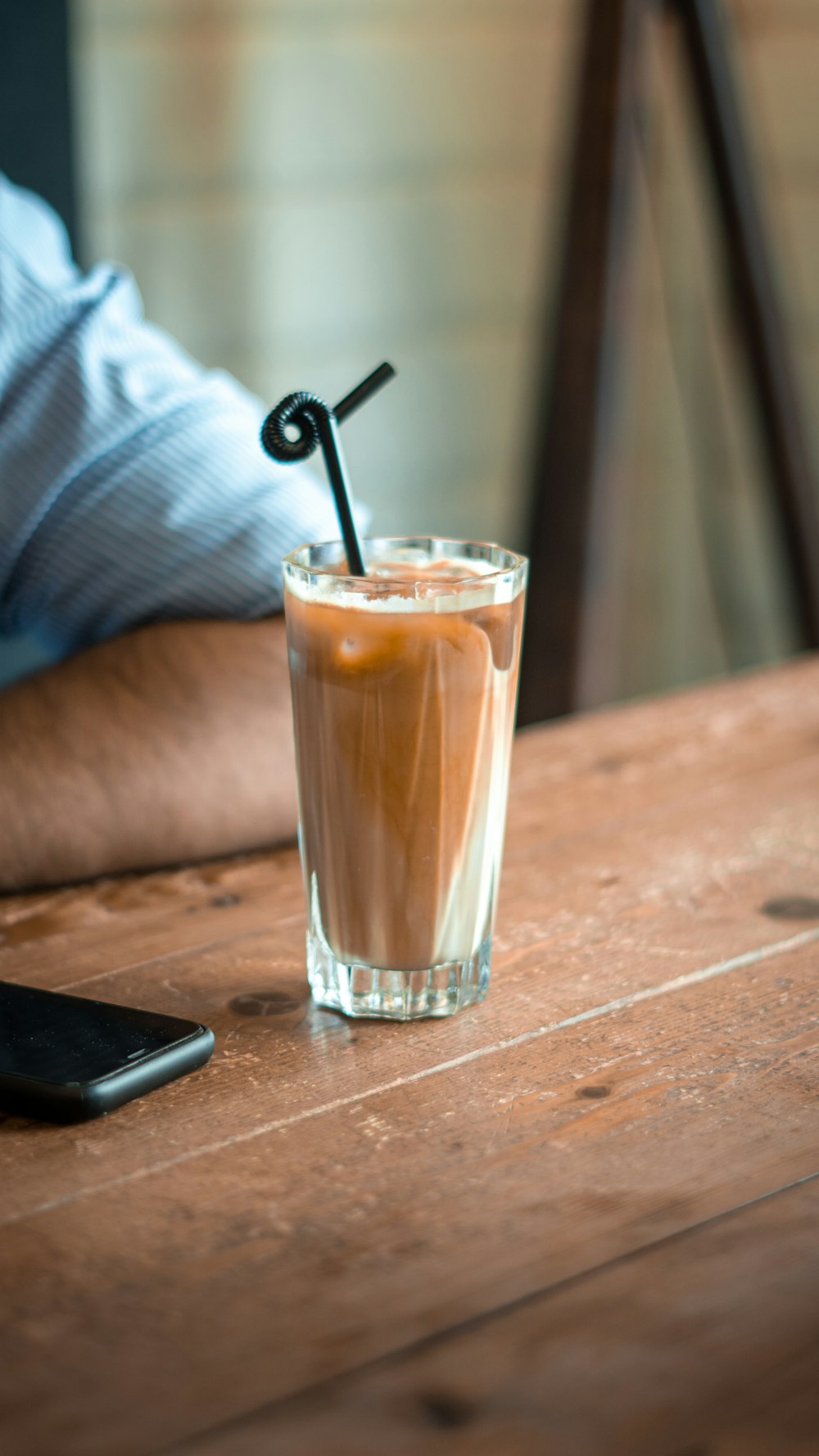 a glass of iced coffee on a wooden table