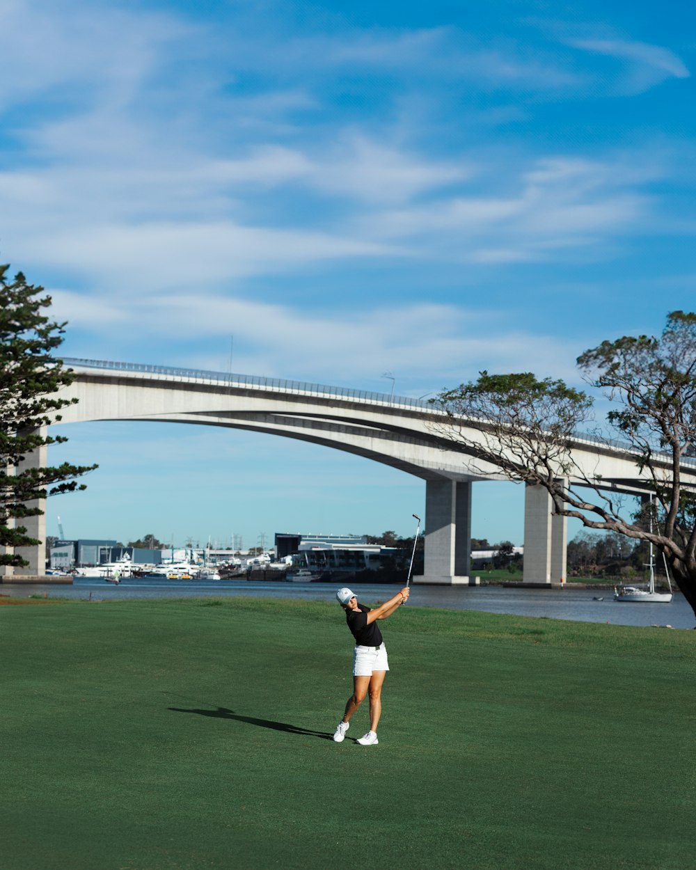 a person on a field with a bridge in the background