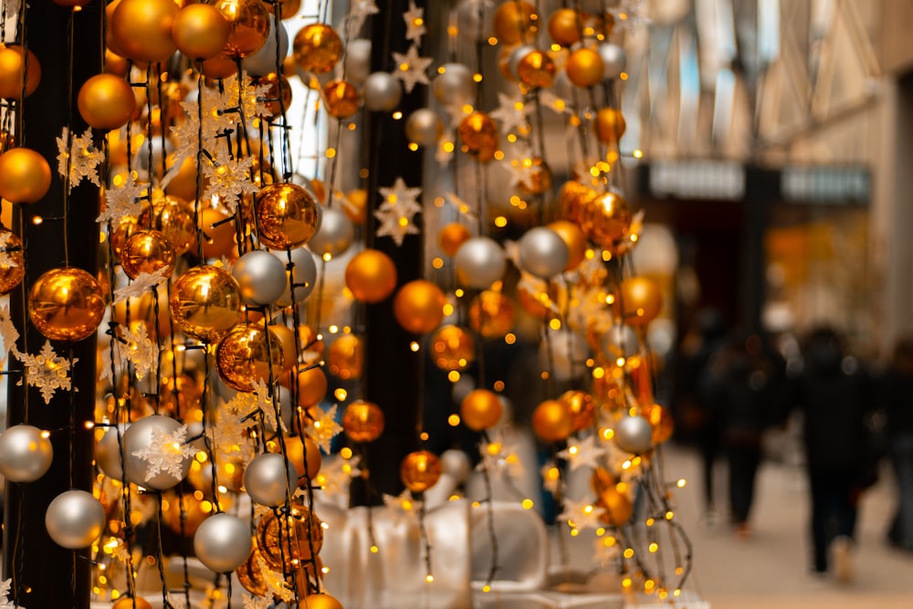 a bunch of gold and silver ornaments hanging from a pole