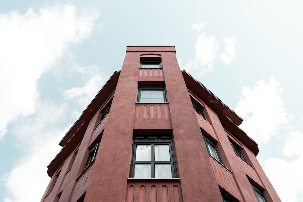 a tall red building with a sky background