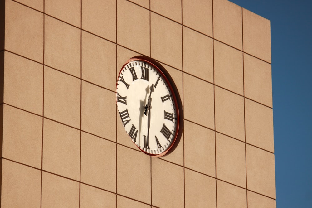 a clock on the side of a building with roman numerals