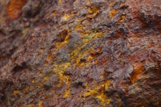 a close up of a rock with yellow and brown paint