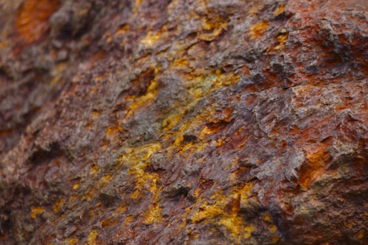 a close up of a rock with yellow and brown paint