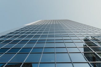 A towering skyscraper with a minimalist grid pattern reflecting sunlight.